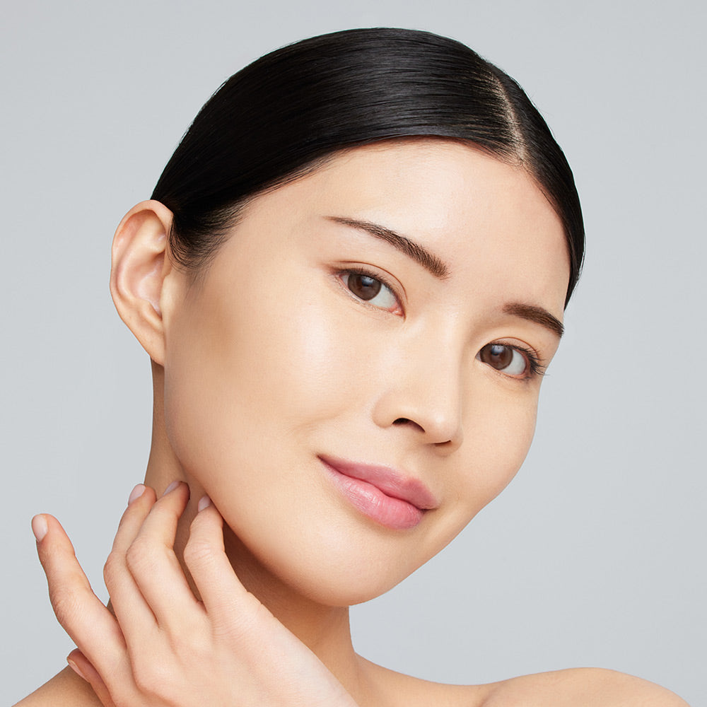 Eine junge Frau trägt die jane iredale Foundation Skintuition und lächelt in die Kamera